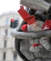 Christmas elf hiding out in a sculpture in a city