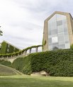 Aarhus Universitets aula set fra universitetsparken på en sommerdag med masser af grønt i parken.
