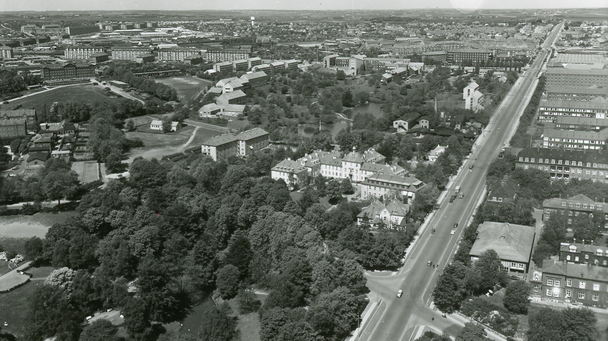 Luftfoto i sort/hvid af kvarteret omkring Nørrebrogade med Fødselsanstalten i Jylland i midten og Vennelystparken i forgrunden.