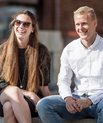 To smilende universitetsstuderende udenfor i solskin