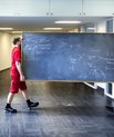 Two movers are moving a big blackboard