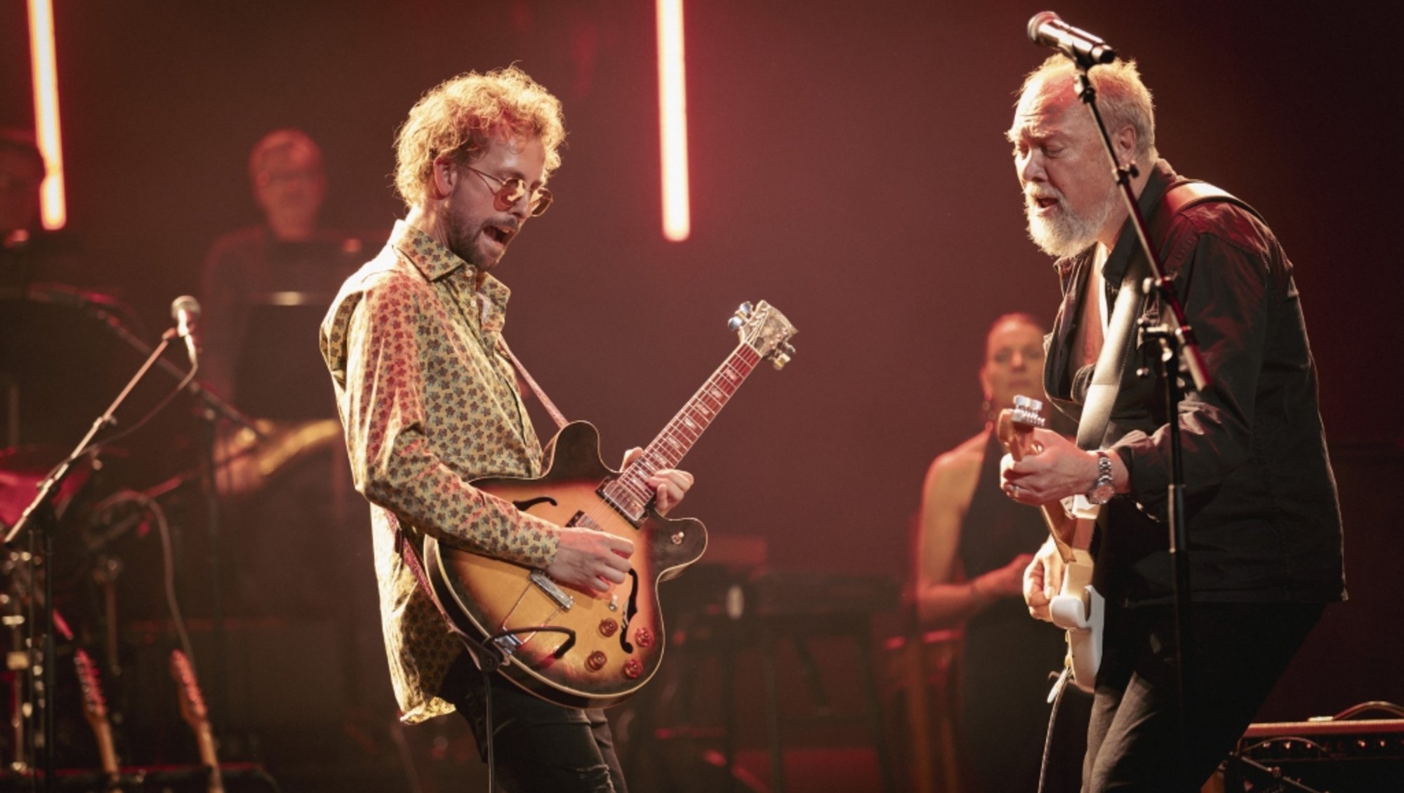 2 guitarister står på scenen ved Aarhus Universitets årsfest om aftenen i Musikhuset Aarhus.