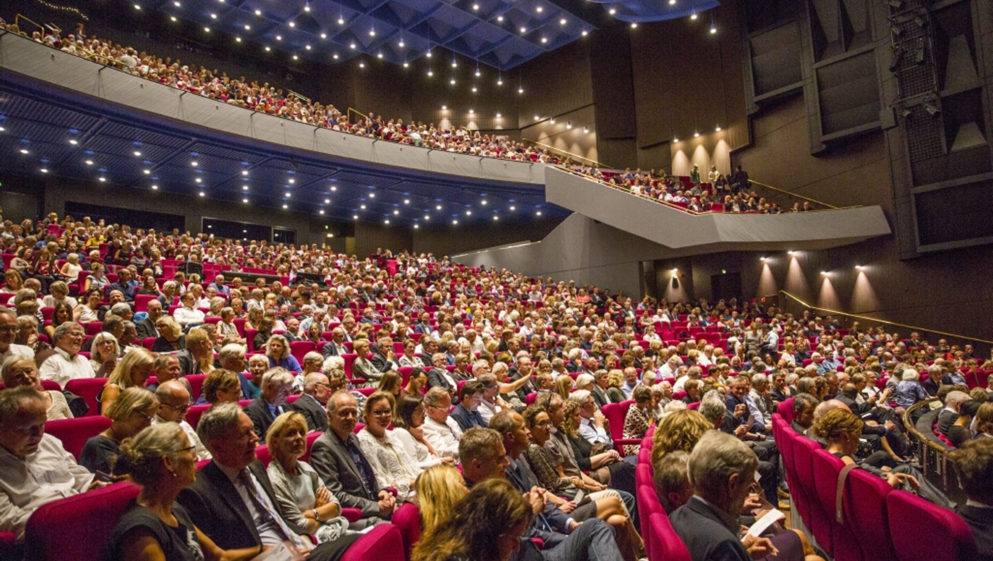 Store sal i Musikhuset Aarhus indefra ved Aarhus Universitets årsfest. Salen er fyldt med publikummer på de mange rækker.