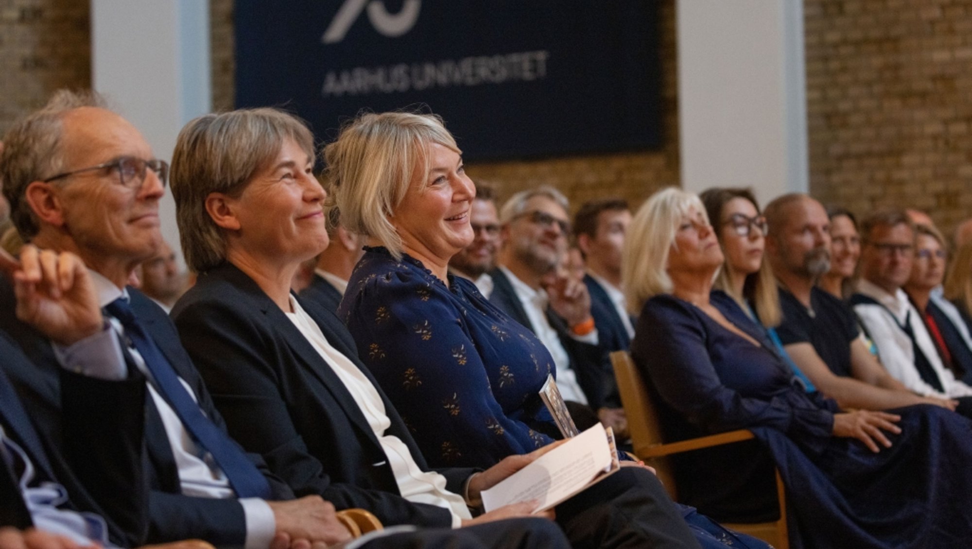 Uddannelses og Forskningsminister Christina Egelund sidder på første række blandt en masse andre deltagere ved Aarhus Universitets årsfest i 2023.